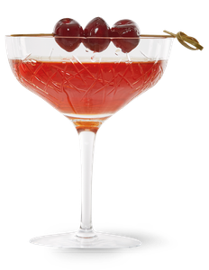 Ein elegantes Cocktailglas mit rotem Getränk, garniert mit drei Kirschen auf einem Holzspieß, strahlt festliche Stimmung aus.