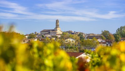 Die sanften Hügel der Stadt sind mit herbstlichen Farben geschmückt, während die Kirche majestätisch über die Dächer ragt.