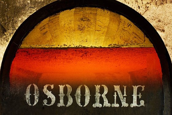 Ein rustikales Fass mit dem Schriftzug 'OSBORNE', umgeben von warmen, leuchtenden Farben, die eine einladende Atmosphäre schaffen.