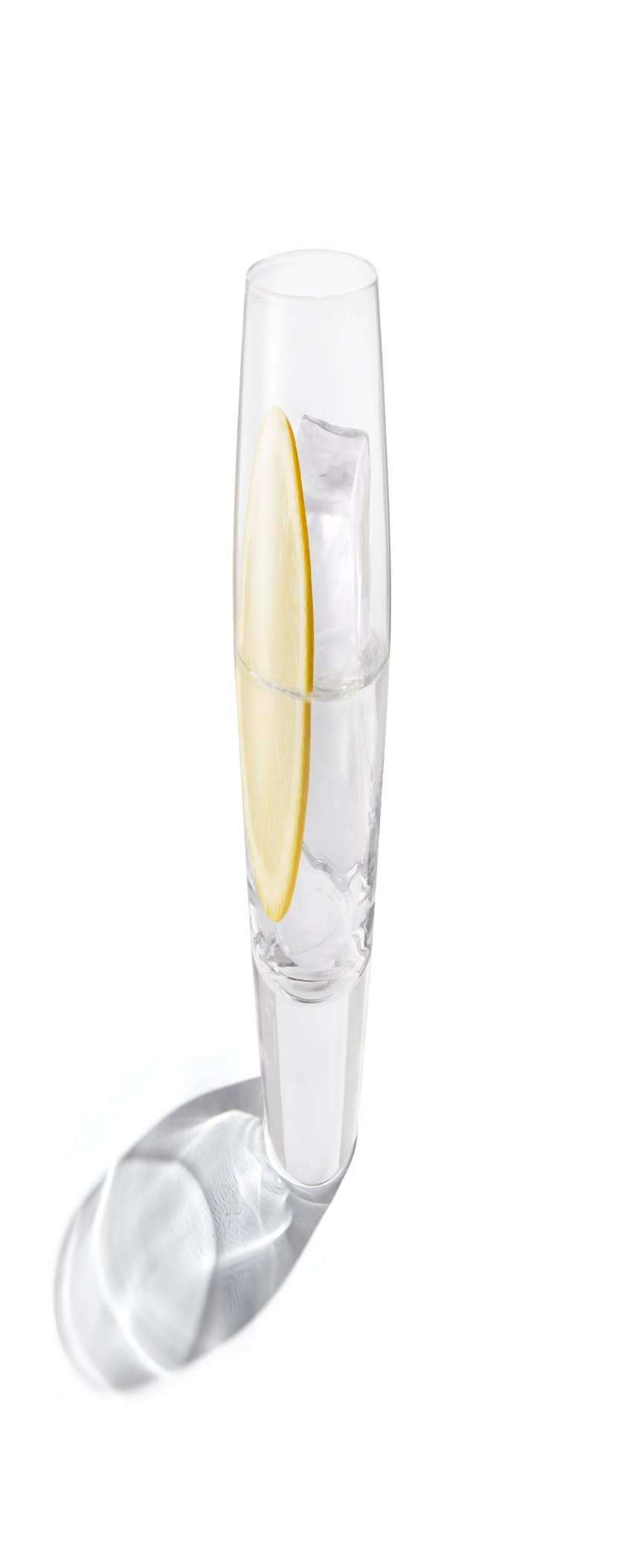 In einem klaren Glas schwimmt ein Eiswürfel, während eine Zitronenscheibe für einen erfrischenden Akzent sorgt.