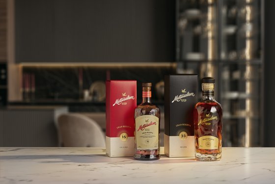 Drei Flaschen Mattusalem Rum stehen auf einem eleganten Tisch, umgeben von stilvollem Interieur und sanftem Licht.