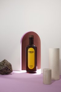 Eine Flasche Whisky mit dem Etikett 'FREUD' steht vor einem sanften, pastellfarbenen Hintergrund und geometrischen Formen.