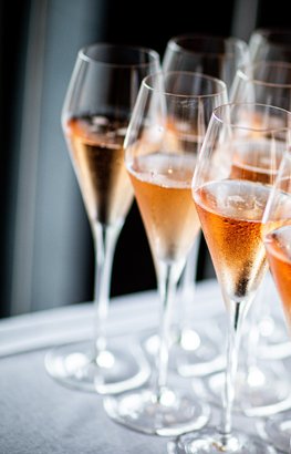 Gläser mit prickelndem rosé Sekt, die in einer ansprechenden Anordnung auf einem Tisch stehen, bereit für einen besonderen Anlass.