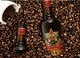 Inmitten von Kaffeebohnen steht eine Borghetti-Flasche, während eine Tasse mit Bohnen im Hintergrund sichtbar ist.