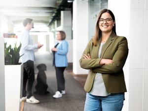 Das Büro ist hell erleuchtet, mit Pflanzen und einem Hund, der die Interaktion zwischen den Menschen beobachtet.
