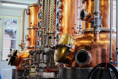 Detailreiche Ansicht einer Brennblase, die mit Rohren und Ventilen ausgestattet ist, um hochwertige Spirituosen zu destillieren.