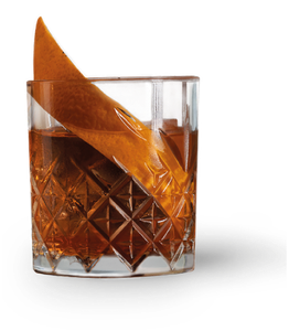 Ein stilvolles Getränk in einem facettierten Glas, das mit einer leuchtenden Orangenschale für zusätzlichen Flair sorgt.