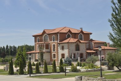 In der sonnigen Landschaft steht ein stilvolles Haus mit einem schönen Garten, das eine entspannte Atmosphäre und viel Grün bietet.
