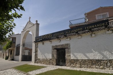 Ein historisches Gebäude mit einem großen Torbogen und einem Schild, das die Bodega Alejandro Fernández anzeigt.
