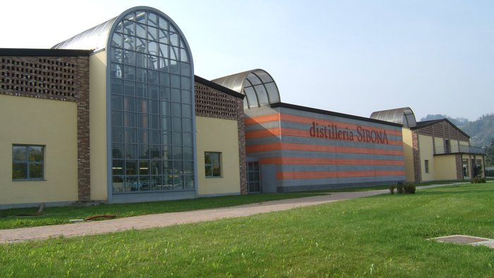 Die architektonisch ansprechende Brennerei Sibona, die durch ihre großen Fenster und die auffällige Farbgestaltung besticht.