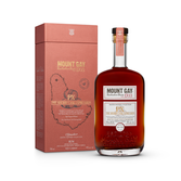 Die Flasche mit dem tiefen Bernsteinfarbton des Mount Gay Rums hebt sich vor der ansprechenden, rotbraunen Verpackung ab.