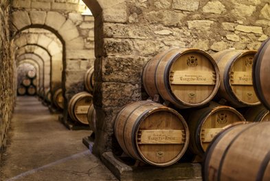 In einem alten Weinkeller stehen mehrere Holzfässer, die mit dem Namen 'Heredero del Marqués de Riscal' beschriftet sind.