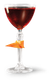 Ein elegantes Glas mit rotem Getränk, verziert mit einer orangefarbenen Schale, strahlt festliche Stimmung aus.