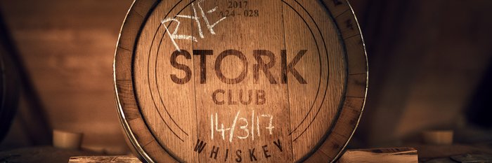 Ein Holzfass mit der Aufschrift 'STORK CLUB' und dem Datum 14/3/17, umgeben von einer warmen, rustikalen Atmosphäre.
