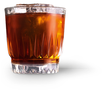 Ein Glas mit einem aromatischen, dunklen Getränk und Eiswürfeln, das eine einladende Atmosphäre ausstrahlt.