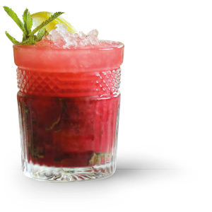 Ein Glas mit einem leuchtend roten Getränk, das mit Eis gefüllt ist und mit einer Limettenscheibe sowie Minzblättern geschmückt ist.