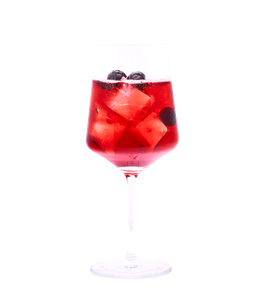 Rubinroter, perlender Drink mit Eiswürfeln und dunklen Beeren in einem hohen Stielglas vor weißem Hintergrund.