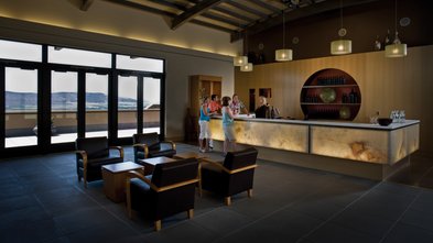 Ein eleganter Empfangsbereich mit einer modernen Bar, wo Gäste mit Barkeepern interagieren und die Aussicht genießen.