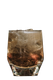 Ein transparentes Glas, gefüllt mit einem goldenen Getränk und Eis, das auf einem dunklen Hintergrund steht.