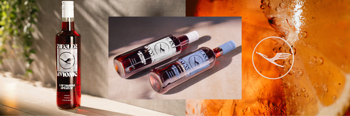 Eine Flasche Ziegler Avionic Aperitif steht vor einem hellen Hintergrund, umgeben von grünen Pflanzen und warmem Licht.