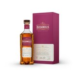 Eine elegante Flasche Bushmills 16 Jahre Single Malt Whiskey steht neben einer stilvollen, lila Verpackung.