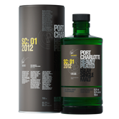 Eine grüne Whiskyflasche mit dem Etikett 'Port Charlotte Heavily Peated' steht neben einer eleganten, runden Dose.