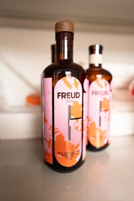 Der Gin mit dem Namen 'Freud' hat ein kreatives Design in Pink und Orange, das die Aufmerksamkeit auf sich zieht.