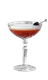Ein elegantes Cocktailglas mit einem schaumigen, rotbraunen Getränk und einer Kirsche auf einem langen Spieß.
