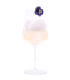 Hellgelber Drink mit üppiger weißer Schaumkrone und einer violetten Blüte als Garnitur in einem hohen Stielglas vor weißem Hintergrund.
