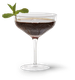 Ein elegantes Cocktailglas mit dunklem Getränk und frischer Minze, das auf einem weißen Hintergrund präsentiert wird.
